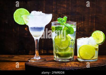Drei Cocktails mit Zitronenalkohol. Brasilianischer Caipirinha, kubanischer Mojito und margarita frozem. Stockfoto