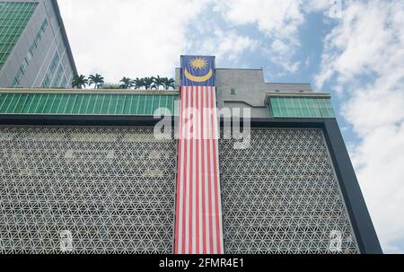 Eine große malaysische Flagge hängt an einem Gebäude in der Stadt melaka malaysia an einem sonnigen Tag mit blauem Himmel. Stockfoto