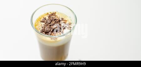 Kaffeegetränk, mit einer nussigen Note mit flauschigem Milchschaum, verziert mit Schokoladenspan, süßem Getränk Stockfoto
