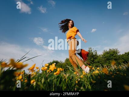 Im Sommer läuft ein junges Mädchen über das Feld. Stockfoto