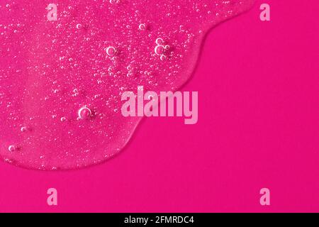 Transparentes kosmetisches oder antibakterielles Gel mit Blasen auf dem leuchtend rosa Hintergrund.gut als Mockup für Kosmetik.Platz für Text oder Design kopieren. Stockfoto