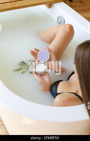 Draufsicht auf Frauenhände mit fester Seife auf weißem Wasserhintergrund, die baden Stockfoto