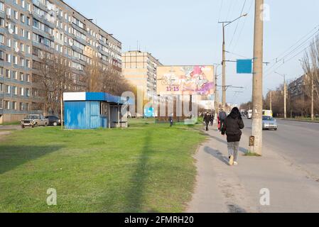 Krivoy Rog. Ukraine. April 2021 Stadtstraße mit Menschen, die entlang der Straße gehen. Vor dem Hintergrund von mehrstöckigen Gebäuden. Stockfoto