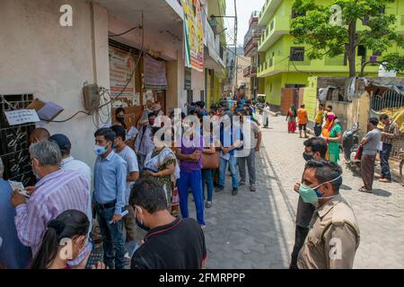 Ghaziabad, Indien. Mai 2021. Menschen mit schützenden Gesichtsmasken stehen in langen Schlangen vor einem Impfzentrum, während sie auf die COVID19-Impfung warten, nachdem die Regierung Uttar Pradesh die Erlaubnis erteilt hatte, Menschen über 18 Jahren zu impfen. Kredit: SOPA Images Limited/Alamy Live Nachrichten Stockfoto