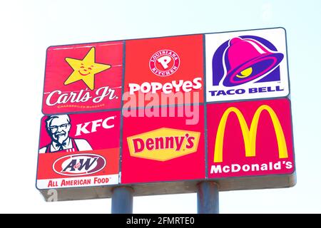 Logos von Carl's Jr., Popeyes, Taco Bell, KFC, Denny s und McDonald's Fast-Food-Restaurants auf dem Straßenschild. Autobahn Autobahn-Werbeschild. - Stockton, Stockfoto