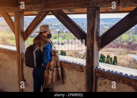 Spaziergang auf dem Balkon von Schloss Olesko, die Frühlingslandschaft mit Maske während der Coronavirus-Pandemie Covid-19 bewundert. Reisen in der Westukraine. Stockfoto