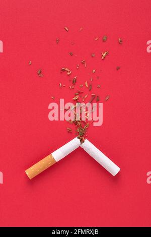 Eine zerbrochene Zigarette und Tabak Spritzer für das Rauchen aufzuhören Konzept. Stockfoto