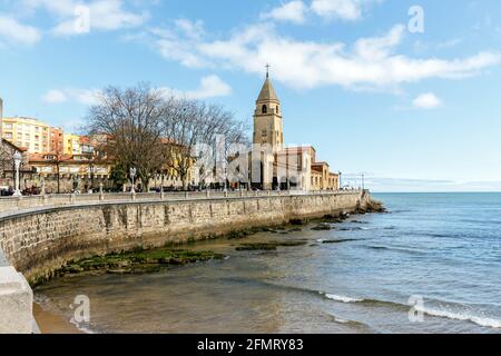 Gijon , Spanien - 31. März 2015: Blick entlang des Strandes von San Lorenzo in Richtung der Halbinsel Santa Catalina, San Pedro Kirche in Gijon in Asturien, Spa Stockfoto