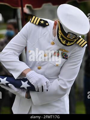 Swoyersville, Usa. Mai 2021. Ein Navy-Dienstmitglied, das eine Gesichtsmask trägt, überprüft die amerikanische Flagge, bevor es sie der Familie gibt. Kredit: SOPA Images Limited/Alamy Live Nachrichten Stockfoto