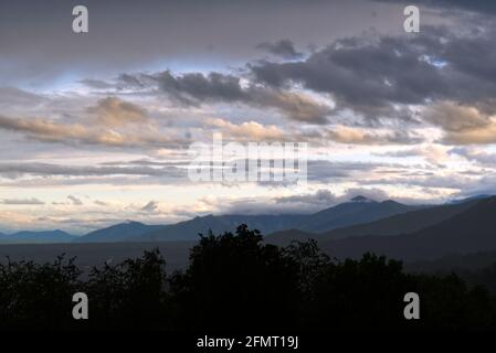 Ein wolkig gewitterter Sonnenuntergang über den italienischen Alpen nach einem Gewitter Stockfoto