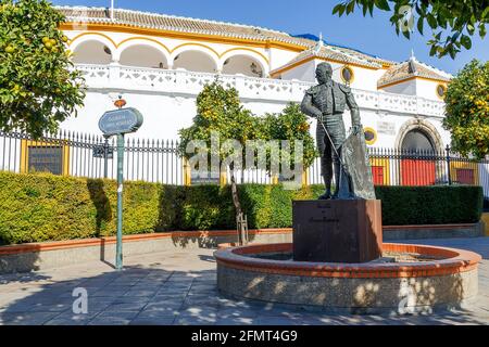 Die Stierkampfarena, Plaza de Toros de la Real Maestranza de Caballeria de Sevilla, mit Matador-Statue im Vordergrund, Sevilla, Provinz Sevilla, Andalus Stockfoto