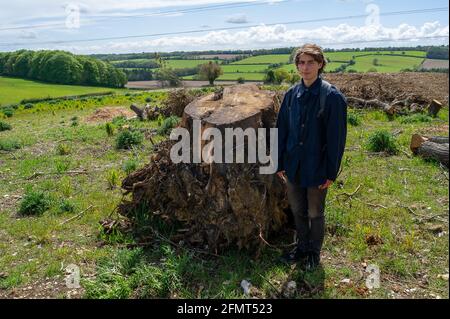 Aylesbury Valle, Buckinghamshire, Großbritannien. Mai 2021. Ein Junge steht neben dem Stumpf einer Eiche vor der Bowood Lane, die von HS2 für eine temporäre Haul Road gefällt wurde. Die Hochgeschwindigkeitsstrecke HS2 von London nach Birmingham zeigt eine riesige Narbe über die Chilterns. Quelle: Maureen McLean/Alamy Stockfoto