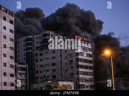 Gaza-Stadt, Der Gazastreifen, Palästina. Mai 2021. Der Hanadi-Wohnturm wurde von einem israelischen Luftangriff getroffen, der inmitten des eskalierenden Aufflackers der israelisch-palästinensischen Gewalt explodierte. Hunderte von Raketen wurden am Dienstag von palästinensischen Aktivisten im Gazastreifen auf Israel abgefeuert, während Israel das kleine Küstengebiet mit Luftangriffen niederschlägt. Kredit: Ahmed Adnan Alsharateha/Quds Net Nachrichten/ZUMA Wire/Alamy Live Nachrichten Stockfoto