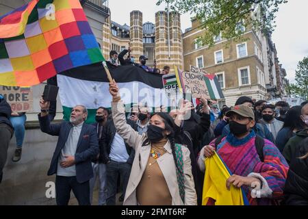 London, Großbritannien. Mai 2021. Kolumbien steht mit Palästina; eine Frau winkt mit einem Wiphala. Mehrere tausend Demonstranten, darunter viele Palästinenser, füllten Whitehall vor der Downing Street in einer Notkundgebung gegen die ethnische Säuberung von Scheich Jarrah im besetzten Jerusalem und die brutalen Polizeiangriffe auf Gläubige in der Al Aqsa Moschee und andere Demonstranten sowie die äußerst unverhältnismäßigen Bombenangriffe als Reaktion darauf Aus Gaza abgefeuerte Raketen, die viele größtenteils zivile Todesfälle verursacht haben. Peter Marshall/Alamy Live News Stockfoto