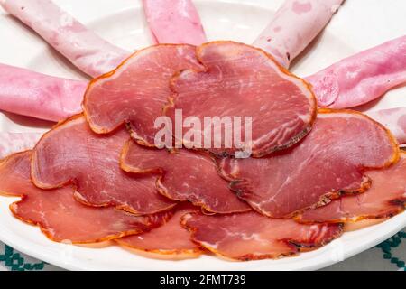 Spanischer Schinken, Fuet, iberischer Schweinelende, präsentiert auf einem Teller Stockfoto