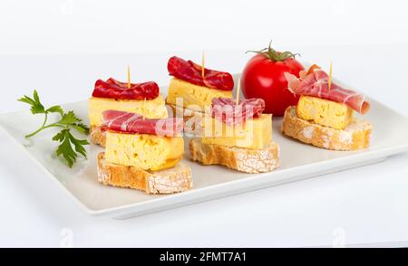 dünne Scheiben von iberischen Wurst Omelett mit Brot auf weiße Grundfarbe Stockfoto