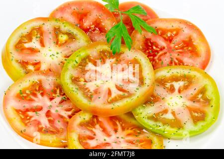 Grüner Tomatensalat mit Olivenöl, Salz und aromatischen Kräutern Stockfoto
