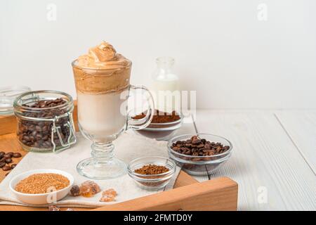 Koreanisches belebendes Getränk mit Schlagkaffeeschaum und Milch auf weißem Hintergrund. Dalgon-Kaffee. Seitenansicht, Kopierbereich. Stockfoto