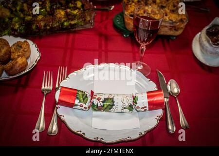 Weihnachtscracker auf dem Teller mit Rotwein zum Weihnachtsessen Tabelle Stockfoto