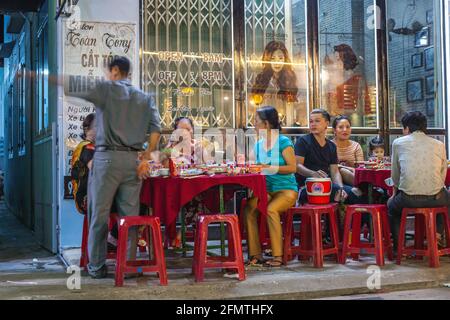 Vietnamesische Familien saßen im Straßencafé vor dem Friseursalon, Hoi an, Vietnam Stockfoto