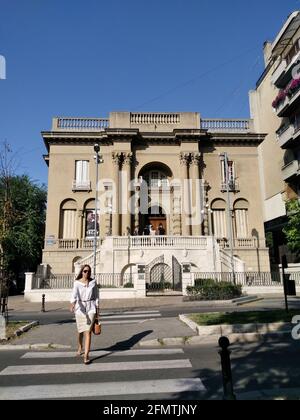 Nikola Tesla Museum und wunderschöne Frauen, die an sonnigen Tagen auf der Straße vor dem Museum spazieren. Fassade des Museums. Stockfoto