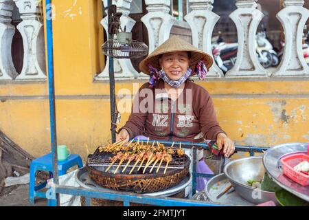 Vietnamesische weibliche Street Food Verkäuferin bereitet Grillfleisch auf Spieße, Hoi an, Vietnam Stockfoto