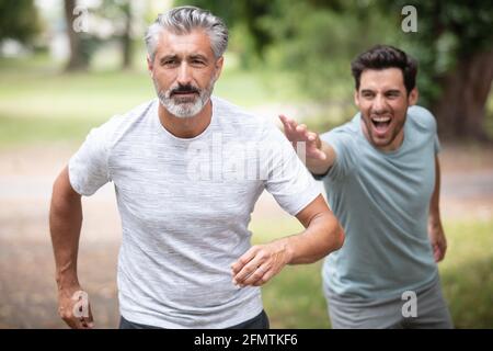 Zwei Freunde laufen auf einem Joggingpfad durch den Wald Stockfoto