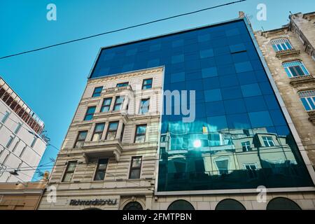 Apartments und Geschäfte in der istiklal Straße in istanbul am frühen Morgen. Modernes Gebäude und antikes Gebäude in demselben Gebäude aus Glas Stockfoto