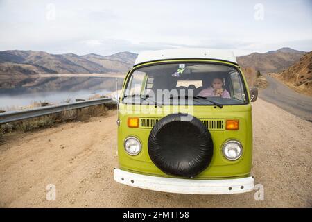 Eine Frau und ihr Hund sind durch die Windschutzscheibe von sichtbar VW-Wohnmobil Stockfoto