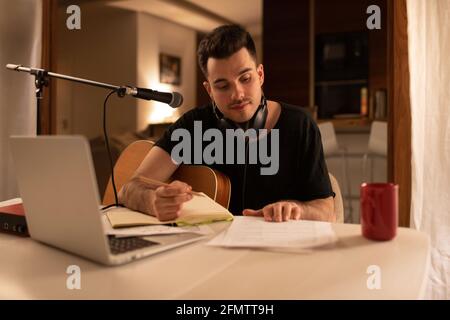 Junger Mann, der Musik im Heimstudio kreiert Stockfoto