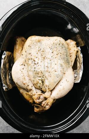 Foto von einem gekochten ganzen Kräuterhuhn in einem Crockpot Stockfoto