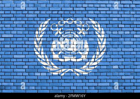 Flagge der Internationalen Seeschifffahrtsorganisation auf Ziegelwand gemalt Stockfoto
