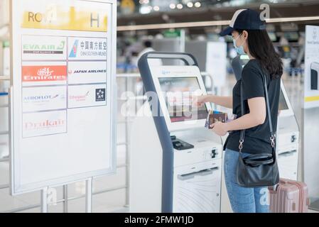BANGKOK THAILAND APR 14 2021 weibliche Hand, die den Check-in mit Selbstbedienung nutzt, um die Bordkarte am Flughafen zu erhalten. Stockfoto