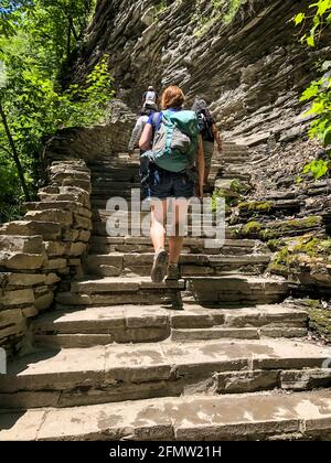 Rückansicht einer kaukasischen Frau, die im Sommer Steintreppen im Watkins Glen State Park, New York, USA, hochgeht. Sehenswürdigkeiten. Juni 2019. Stockfoto