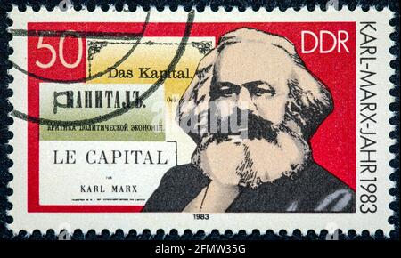 DEUTSCHLAND - UM 1983: Eine in der DDR gedruckte Briefmarke zeigt Karl Marx und das Buch "Kapital" um 1983 Stockfoto