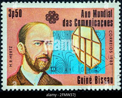 GUINEA - BISSAU - UM 1983: Eine in Guinea-Bissau gedruckte Briefmarke, die dem Weltkommunikationsjahr gewidmet ist, zeigt einen deutschen Physiker Heinrich Hertz circ Stockfoto