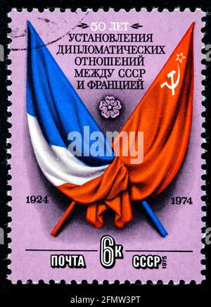 UdSSR - UM 1975: Die in der UdSSR gedruckte Marke zeigt Flaggen und Waffen Frankreichs und der UdSSR-Fabriken um 1975. Stockfoto