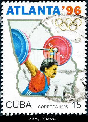 KUBA - UM 1995: Eine in Kuba gedruckte Briefmarke, die den Olympischen Spielen in Atlanta 1996 gewidmet ist, zeigt Gewichtheben um 1995 Stockfoto