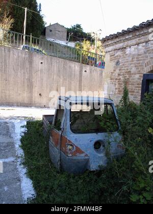 Rostige dreirädrige Abholung in überwucherten Unkräutern in Karousades, Korfu, Griechenland Stockfoto