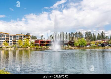 Riverstone öffentlicher Park und See mit dem Wasserbrunnen während des Frühlings in der Riverstone kommerziellen Entwicklung in der Innenstadt von Coeur d'Alene, Idaho, USA Stockfoto