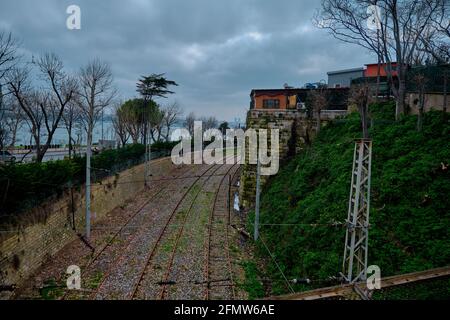 Bewölktes Wetter in istanbul im Winter. Eisenbahnen und alte Vintage-Häuser in der Nähe der alten Eisenbahnstraße auf der europäischen Seite istanbuls mit Wolkenlandschaft und Regen Stockfoto