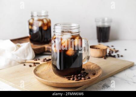 Mason Gläser mit leckeren kalten Brühe und Kaffeebohnen auf Weißer Hintergrund Stockfoto