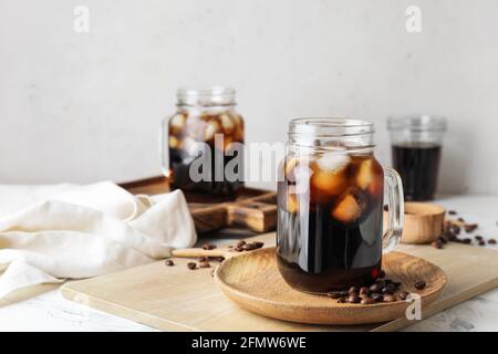 Mason Gläser mit leckeren kalten Brühe und Kaffeebohnen auf Weißer Hintergrund Stockfoto