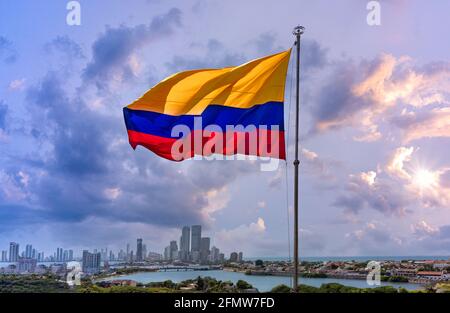 Die Flagge schwankt vor dem malerischen Blick auf die moderne Skyline von Cartagena in der Nähe des historischen Stadtzentrums und der Hotelzone des Resorts. Stockfoto