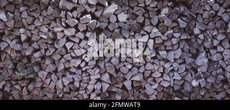 Wand aus gestapelten Kiefernholzstämmen als Hintergrund. Stapel von Holzstämmen übereinander gestapelt. Wand aus gestapelten Holzstämmen. Protokolle Schnitte vorbereitet Stockfoto