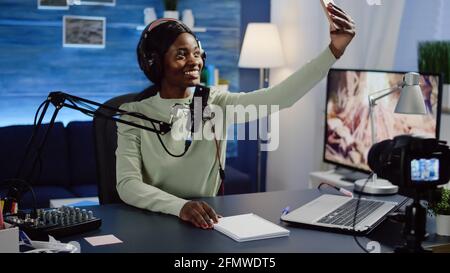 Afrikanische Bloggerin, vlogger Portrait macht Fotos von sich selbst auf dem Smartphone. Content Creator, On-Air-Online-Produktion Internet Broadcast Show Host Streaming Live-Inhalte für Social Media. Stockfoto