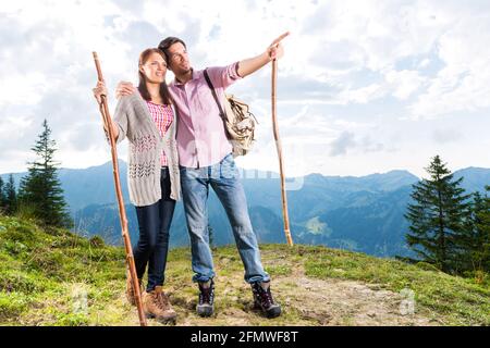 Wandern - junges Paar am Gipfel des Berges in den Bayerischen Alpen genießen das Panorama in ihrer Freizeit oder Urlaub Stockfoto