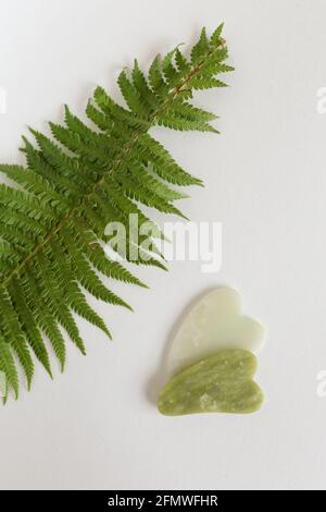 Gua Sha Massagegerät auf weißem Hintergrund. Konzept der Schönheit Gesichtswerkzeuge. Platz für Text. Leer für Schönheitssalon auf Massagesalon Stockfoto