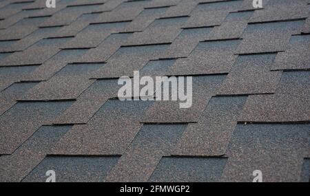 Architektonische, dimensionale Asphalt Schindeln Dachmaterial Hintergrund. Braun, Kupfer Asphalt Schindeldach Textur. Stockfoto