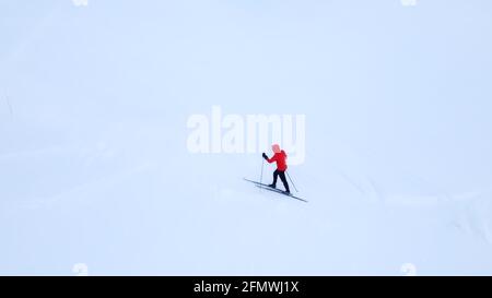 Skilanglaufläufer, die über eine schneebedeckte arktische Tundra fahren. Stockfoto